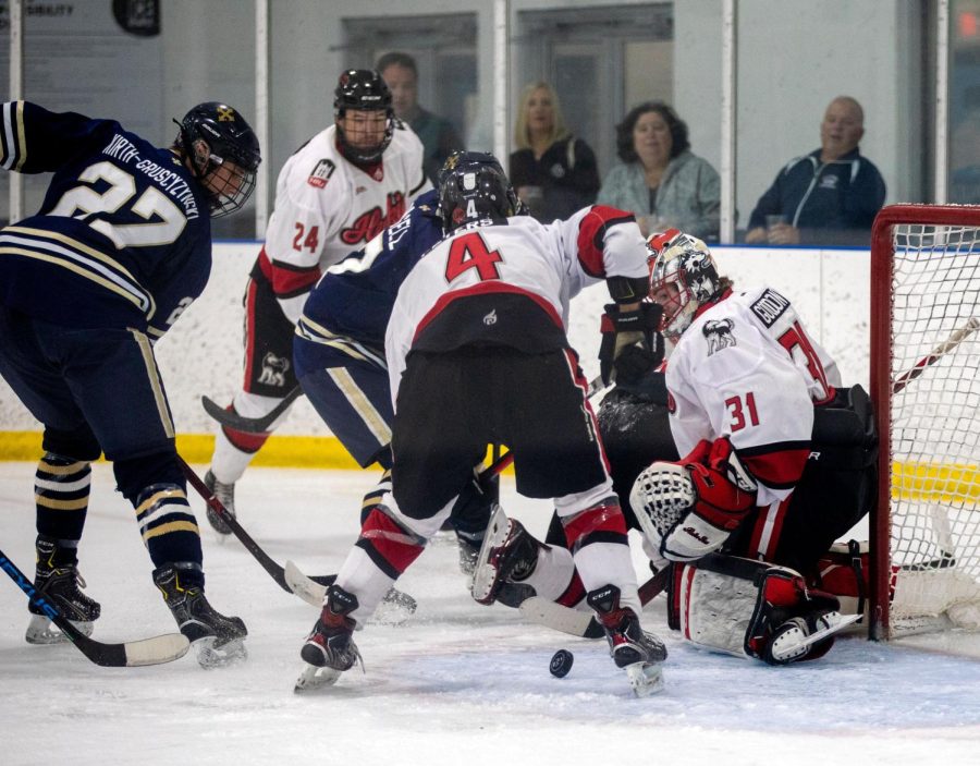 Sophomore defenseman Brandon Peters and sophomore goaltender Grant Goodson battle for possession of the puck in front of NIUs goal during a matchup against the John Carroll University on Sept. 16. The Huskies allowed seven shots into their net in a 7-1 loss to open their 2022 campaign. (Beverly Buchinger | NIU Hockey)