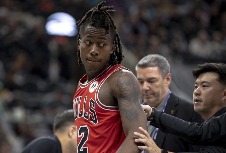 Chicago Bulls guard Ayo Dosunmu is led off the court by the Bulls medical team for concussion protocols during the second half of an NBA basketball game against the San Antonio Spurs on Friday in San Antonio, Texas.