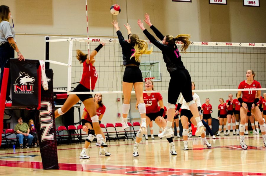 Outside hitter Katie Jablonski (center) and middle blocker Sammi Lockwood attempt to block an attack from Ball States opposite hitter Natalie Mitchem during NIU volleyballs Friday night match at Victor E. Court. (Alyssa Queen | Northern Star)