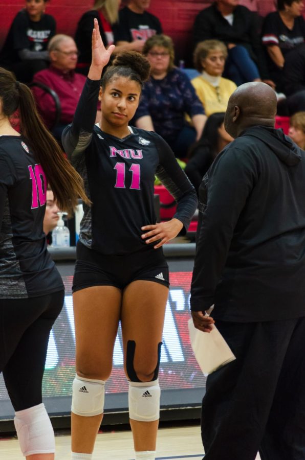 Sophomore middle blocker, Charli Atiemo, speaks with head coach Ray Gooden between sets during Friday’s match against Bowling Green at Victor E. Court. (Alyssa Queen | Northern Star)