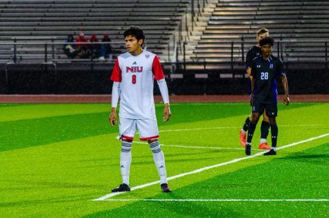 Midfielder Camilo Estrada (Left) standing in the rain waiting for the to return into play during the Huskies Oct. 12, 2022 mens soccer game against Northwestern University at the NIU soccer and track & field complex. (Alyssa Queen | Northern Star)