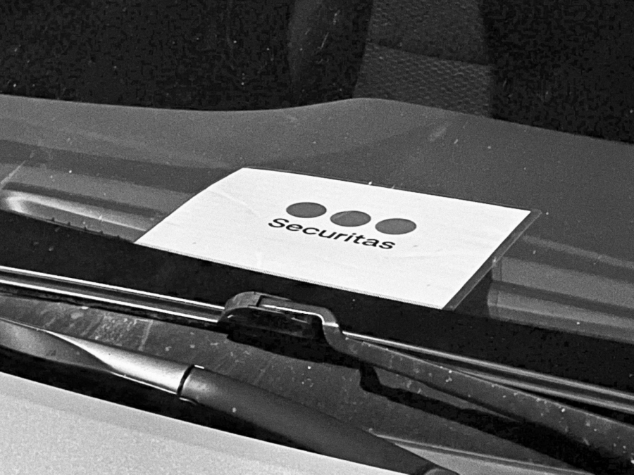 A Securitas placard rests on a car dashboard outside Grant North Residence Hall.