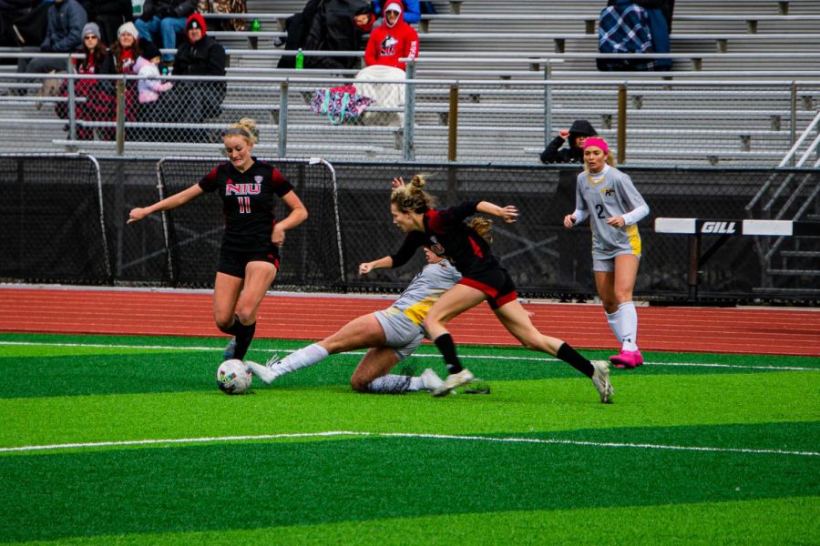 Lea Gruennagel (left) and Madison Looby attempting to steal the ball in the team's tied match Sunday  against Kent State on the huskie's home turf. (Mingda Wu | Northern Star)