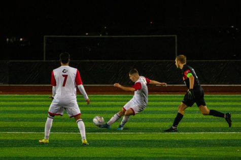 Fifth year midfielder Adrian Corona passing the ball downfield to a teammate during the teams losing match against BGSU on Tuesday night at the NIU Soccer and Track & Field Complex. (Mingda Wu | Northern Star)