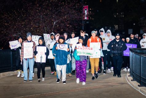 (From left) NIU students Maggie Van Heemst, Raeleen Trovelq, Angel Cabang and Susan Johnson leading the Take Back the Night march Wednesday night across campus.(Mingda Wu | Northern Star)