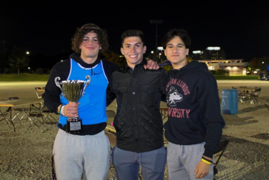 Freshman Charlie Zaknoun, an industrial engineering major, sophomore Matt Estrada, a finance major and sophomore Mark Branklin, kinesiology major, standing at the end of Friday night’s bonfire near the Outdoor Recreation Sports Complex. (Nyla Owens | Northern Star)