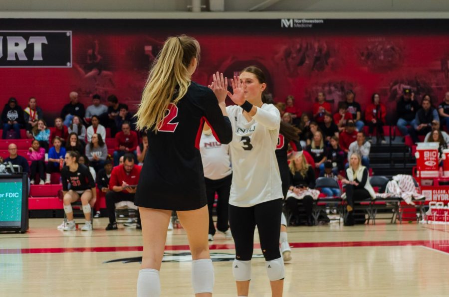 Katie Jablonski (Left) and Francesca Bertucci high fiving before the team’s Saturday game against CMU. (Alyssa Queen | Northern Star)