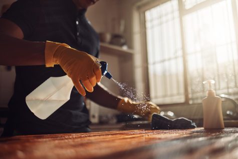 A man cleaning his countertop in the kitchen. Columnist Quade Evans believes men should take on chores like cleaning and laundry more often and be taught at a young age. 