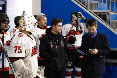 From left: Goalies Ben Vutci, a junior, and Jacob Stermin, a freshman standing in front of the rest of their team with NIU Hockey head coach Brad Stoffers as they exit their locker room before the third period of the team’s game on Saturday at Canlan Sports in West Dundee. (Sean Reed | Northern Star)