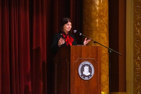 NIU President Lisa Freeman arrives at the podium to begin her State of the University address on Tuesday in the Altgeld Hall Auditorium. (Sean Reed | Northern Star)