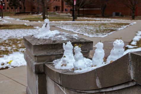 Miniature snowmen sit atop the barrier of a bridge on Tuesday afternoon between Neptune and Cole Halls. The National Weather Service has set a winter weather advisory for tomorrow. (Nyla Owens | Northern Star)