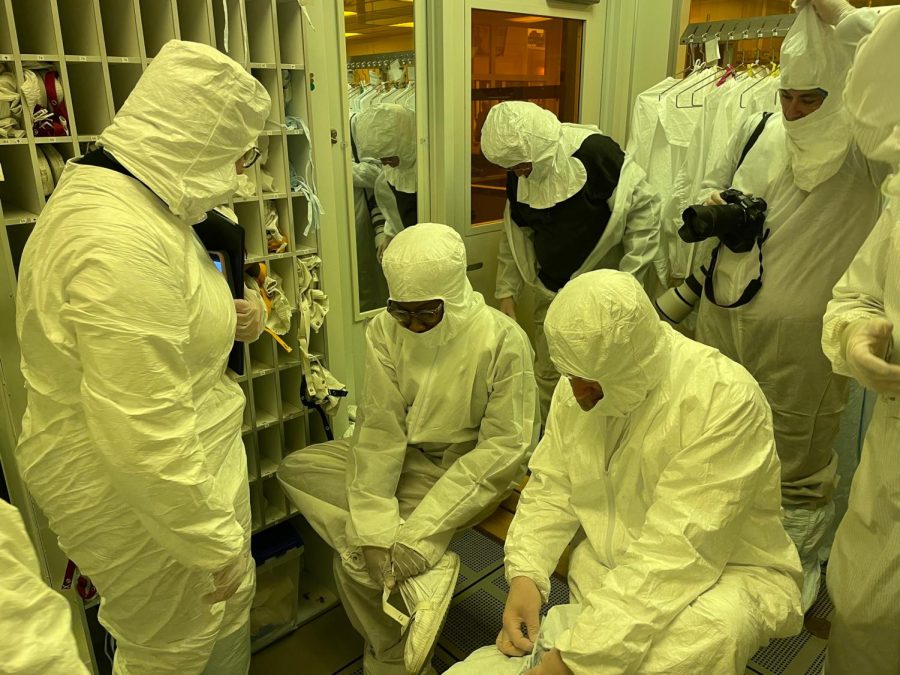 Rep. Lauren Underwood removes personal protective equipment used to keep the lab sterile after her tour Friday of the space. (Colin Kempsell | Northern Star)