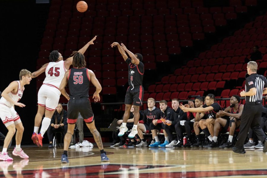 NIU sophomore guard David Coit attempts a three-point jump shot over Miami University senior forward Anderson Mirambeaux in the second half of NIUs 81-77 win Tuesday. (Jake Ruffer | The Miami Student)
