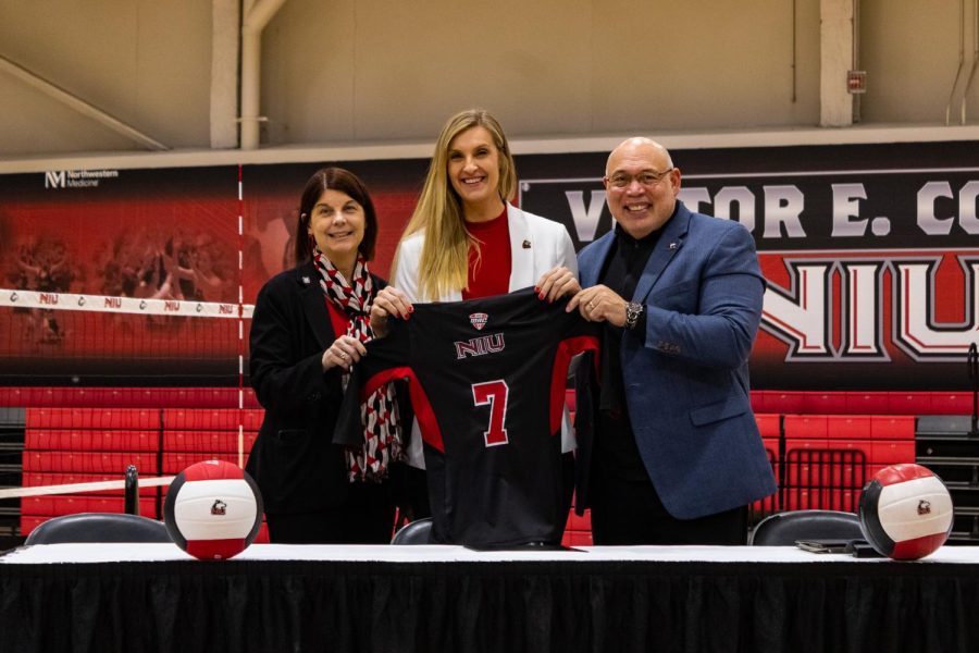 NIU President Lisa Freeman, NIU volleyball head coach Sondra Parys and NIU Vice President and Director of Athletics and Recreation Sean Frazier hold an NIU volleyball jersey bearing the No. 7, representing Parys status as the Huskies seventh head coach in program history. (Sean Reed | Northern Star)