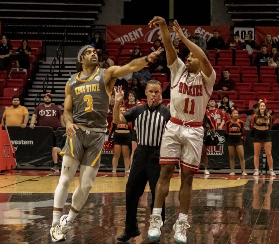 NIU+sophomore+guard+David+Coit+%2811%29+makes+a+three-point+attempt+while+Kent+State+University+redshirt+senior+guard+Sincere+Carry+%283%29+defends+during+Tuesdays+night+Mid-American+Conference+basketball+matchup+at+the+Convocation+Center+in+DeKalb.+The+Huskies+upset+the+Golden+Flashes+86-76.+%28Tim+Dodge+%7C+Northern+Star%29