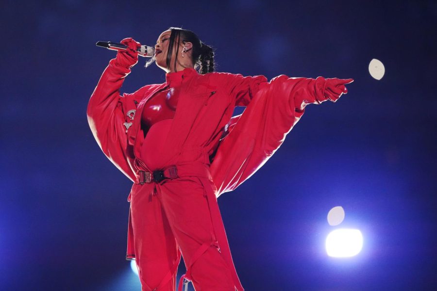 Rihanna in her red outfit shining bright under the spotlights at the Super Bowl Halftime Show.