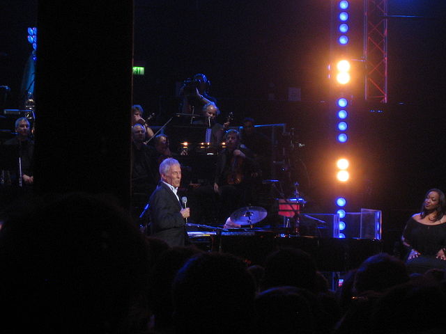 Burt Bacharach playing a piano at a concert. 
