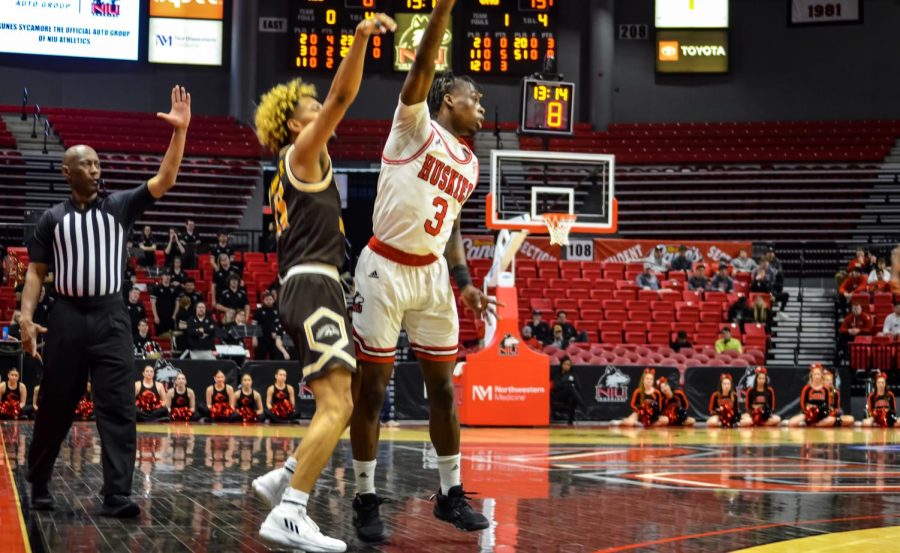 Senior guard Kaleb Thornton (3) tries to defend a shot from Broncos senior guard Lamar Norman Jr. during the Huskies matchup against the Western Michigan Broncos on Feb. 11 at the NIU Convocation Center. (Alyssa Queen | Northern Star)