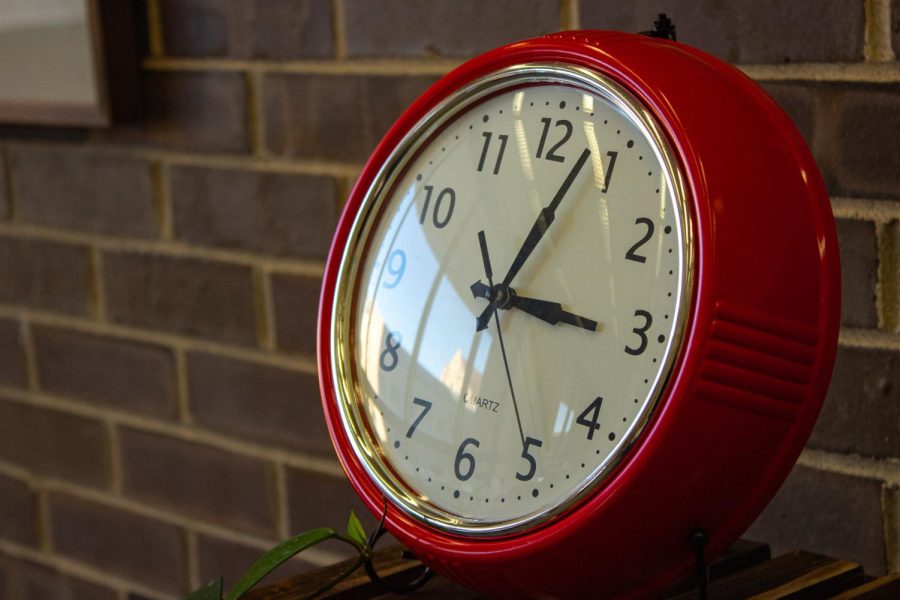 The daylight reflects off of the surface of a bright red clock in the Writing Center located in the Founders Memorial Library. (Cheyanne Quintanilla | Northern Star)