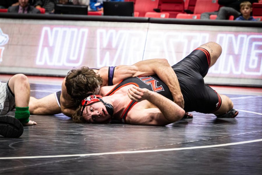 An NIU wrestler is taken down by a Northwestern wrestler in Fridays meet at the Convocation Center. (Mingda Wu)