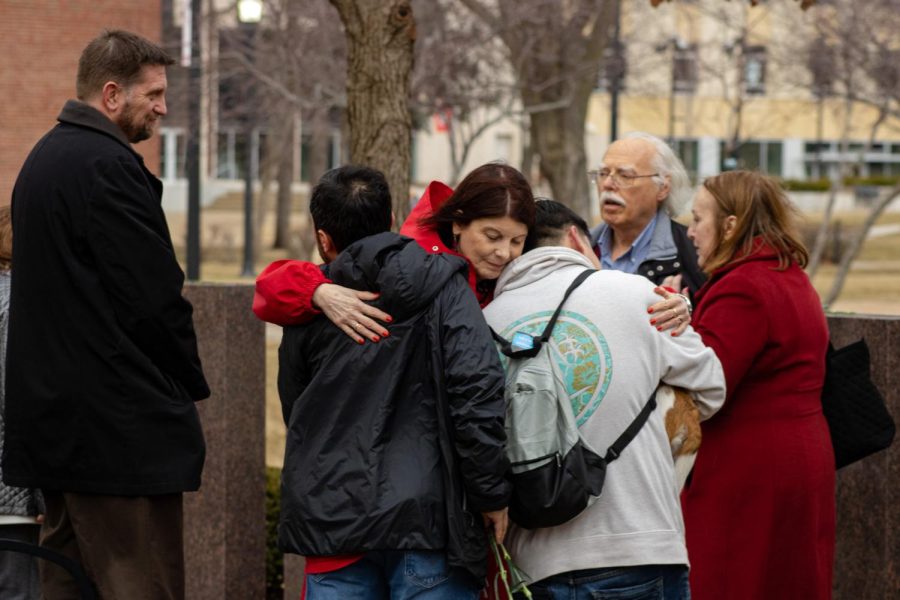 NIU President Lisa Freeman hugging Patrick Korellis (left) and Harold Ng, two surviving victims of the Valentines Day shooting that took place in 2008 within Cole Hall, at the 15-year anniversary Forward Together Forward memorial for the victims this afternoon at the Peaceful Reflection Garden outside of Cole Hall. (Sean Reed | Northern Star)