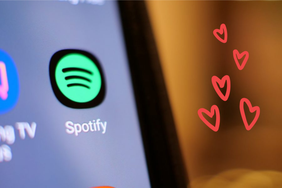The Spotify logo on a computer with hearts in the background.