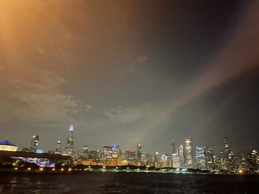 The Chicago Skyline at night with the water in the foreground of the image.