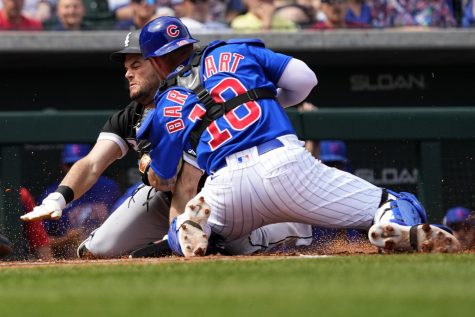 Chicago White Sox Andrew Benintendi is tagged out at the plate by Chicago Cubs catcher Tucker Barnhart while trying to score on a base hit by Yasmani Grandal during the first inning of a spring training baseball game, Friday, March 10, 2023, in Mesa, Ariz. (AP Photo/Matt York)