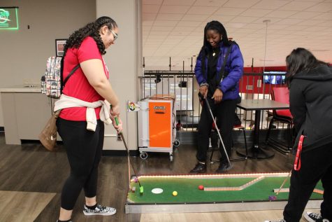 Sophomore Computer science major Alexis Coleman blocking freshman nursing major Jennifer Mondragon and freshman biomedical engineering major Boluwatife Efunkoya from making a hole-in-one Friday night at the Student Holmes Center. (Nyla Owens | Northern Star)