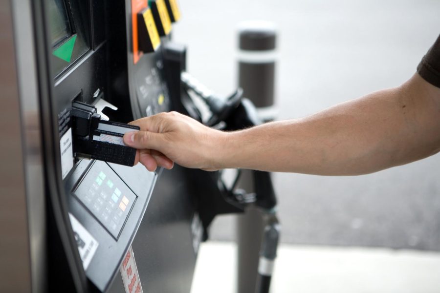 A man paying for gas at a gas pump. Gas prices went up by 6.8 cents per gallon since last week. 