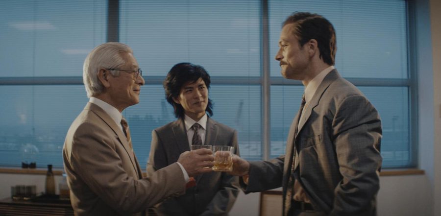 (from left) Togo Igawa, Nino Furuhata and Taron Egerton from the film Tetris share a drink. The film premiered on March 31 on Apple TV+. (Apple TV+ via AP)