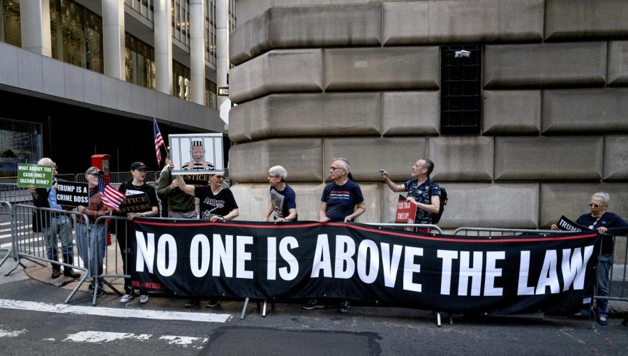 Protesters gather before former President Donald Trump arrives in a motorcade for a deposition in New York Thursday, April 13, 2023. Opinion Columnist Emily Beebe believes Trump is a great example of why we need to hold elected officials to a higher standard of morals. (AP Photo/Craig Ruttle)