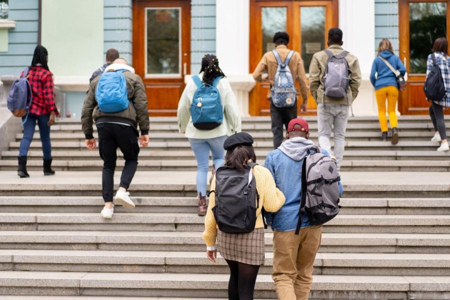 Students walking up stairs on their way to class. The rate of students leaving college with some credits but no degree has gone up 3.6% since 2022.