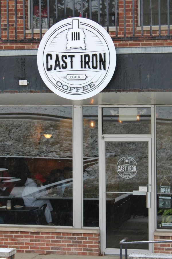 From the exterior of Cast Iron Coffee, lights and people from the inside can be seen. The cafe is an NIU staple and has tons of great drinks. (Nyla Owens | Northern Star)