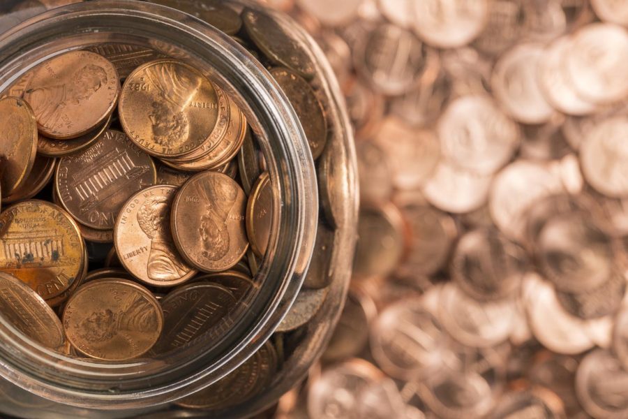 A birds eye view of a jar overflowing with pennies. Columnists Lucy Atkinson and Emily Beebe debate whether America should keep the copper coin in the currency.