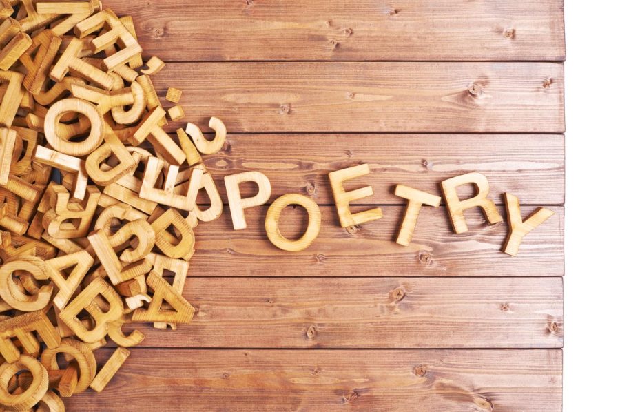 Word poetry made with block wooden letters next to a pile of other letters over the wooden board surface composition. April is national poetry month. (Getty Images)
