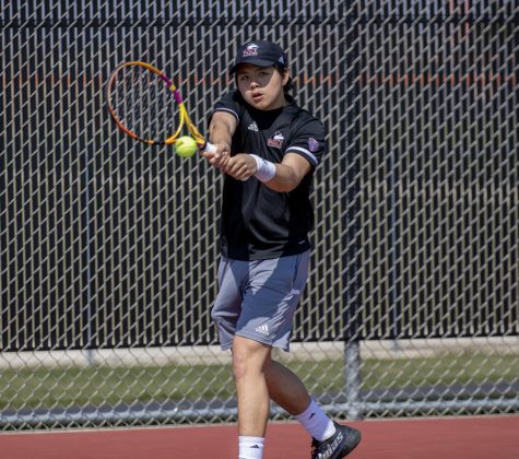 Junior Cheng En Tsai returns a serve from his opponent Friday afternoon. The University of Toledo Rockets defeated the Huskies 4-3. (Tim Dodge | Northern Star)