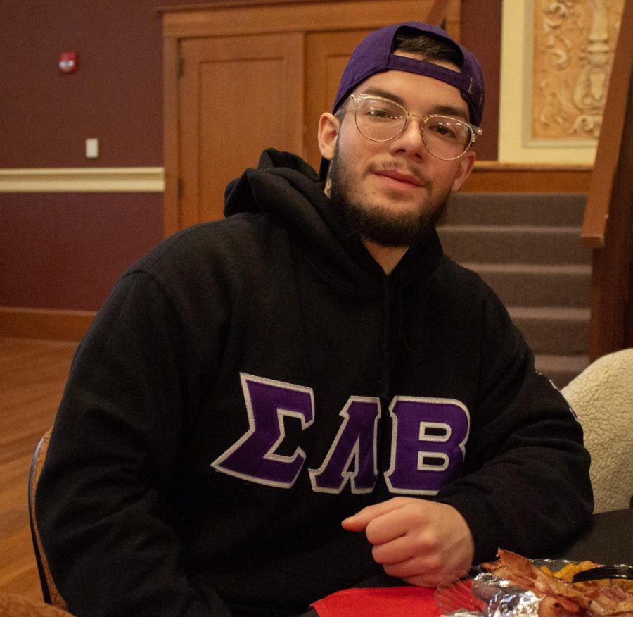 Elian Garcia, a senior marketing major and member of Sigma Lambda Beta, sitting during the breakfast in Altgeld Hall. Volunteers got free shirts and could enjoy a complimentary breakfast before heading out to a volunteer location. (Madelaine Vikse | Northern Star)
