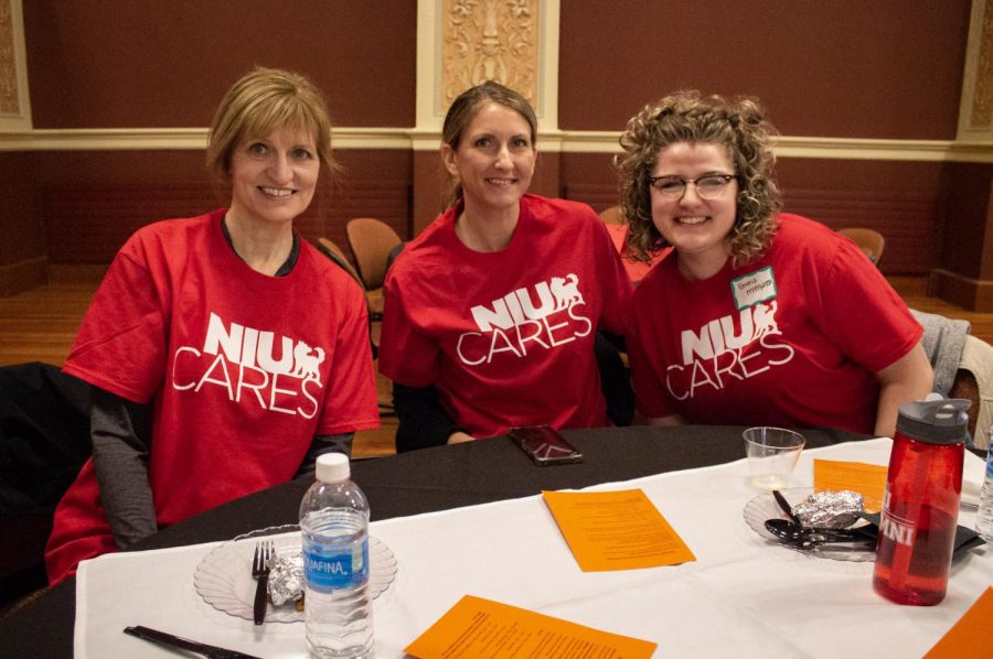 Diane Johnson (left), director of donor relations for the NIU Foundation, Amy Ogden, associate director of donor relations for the NIU Foundation and Emma McMahon, associate director of donor relations for the NIU Foundation sit at a table during the free breakfast in the Altgeld Hall Auditorium. (Madelaine Vikse | Northern Star) 