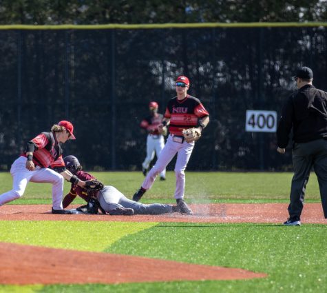 Junior infielder Andre Demetral (1) puts the tag down on a Central Michigan University player as he attempts to steal second base while junior infielder Aaron Harper (22) looks on. The Huskies were defeated by the Chippewas 17-7 on April 8. (Tim Dodge | Northern Star)