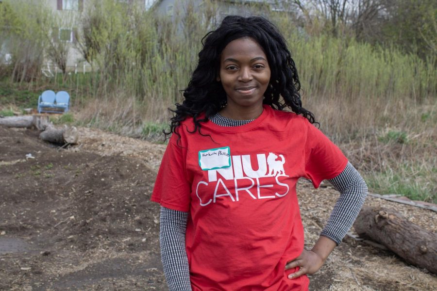 Kurleisha Phillips, a senior communication major, volunteers in the afternoon Friday at the DeKalb County Community Garden, 2475 Bethany Road. (Madelaine Vikse | Northern Star)