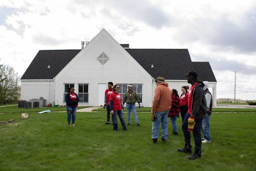 Volunteers stand and chat in front of the New Hope Missionary Baptist Church after completing their gardening work. The church was one of the locations volunteers went to in order to help out for NIU Cares, an annual day of service. (Madelaine Vikse | Northern Star)