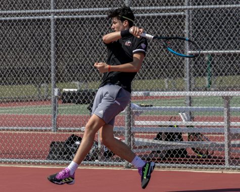 NIU freshman tennis player Iker Gaztambide Arrastia completes a serve against University of Toledo’s Marko Galic, a senior, during their singles match on April 7 at DeKalb High School. (Tim Dodge | Northern Star)