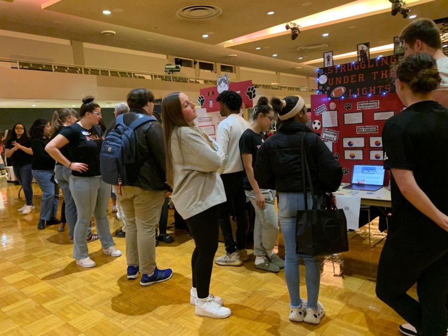 Students looking at the reports from other students' projects for English 203. Students' projects encompassed their concerns and interests at NIU. (Rachel Cormier)