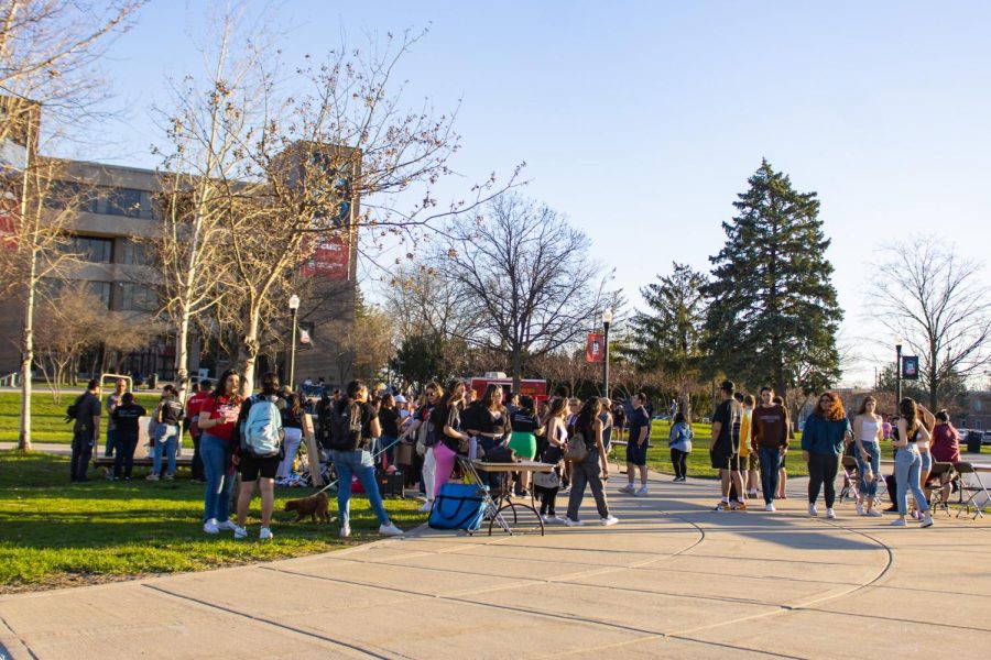 NIU students crowding around a table to recieve tickets for free food from the food truck in MLK Commons. (Sean Reed | Northern Star)
