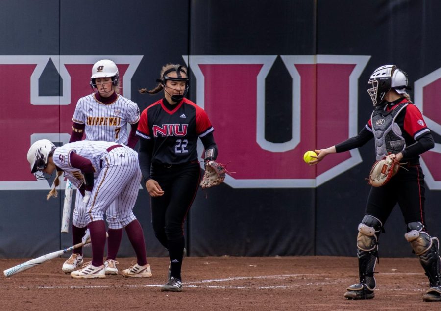 NIU freshman utility player Danielle Stewart (22) reaches for the ball as junior catcher Ellis Erickson (23) passes it to her at home plate during NIU Softballs home game against Central Michigan University March 31 at Mary M. Bell Field. (Tim Dodge | Northern Star)