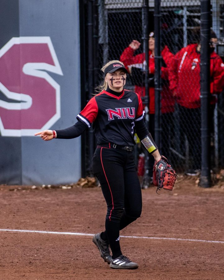 NIU+junior+infielder+Caitlyn+Shumaker+%283%29+points+to+communicate+with+a+coach+before+an+inning+on+March+31.+%28Tim+Dodge+%7C+Northern+Star%29