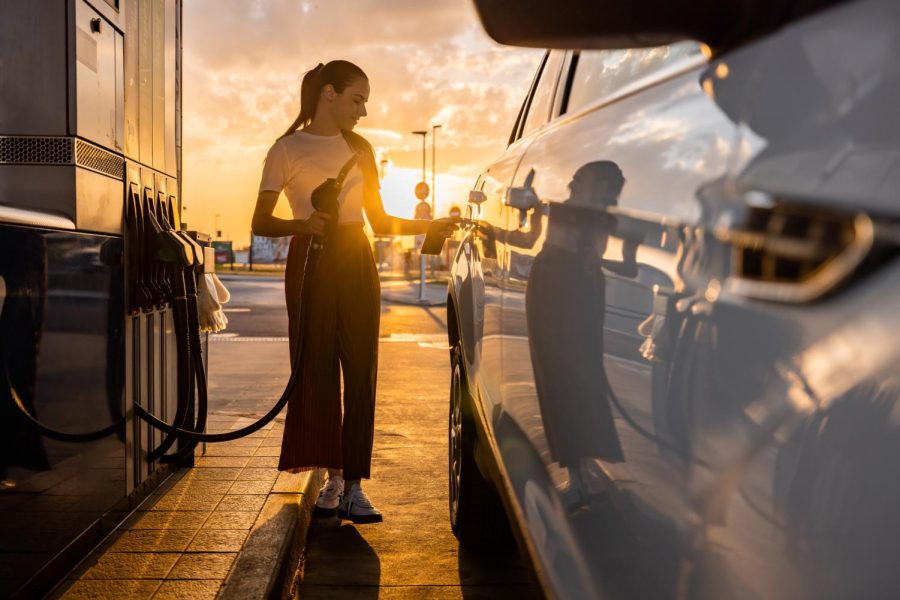 A+woman+holding+a+gas+pump+to+fill+up+her+cars+tank.+Gas+prices+were+expected+to+hit+peak+between+May+and+June+but+mightve+hit+earlier.+