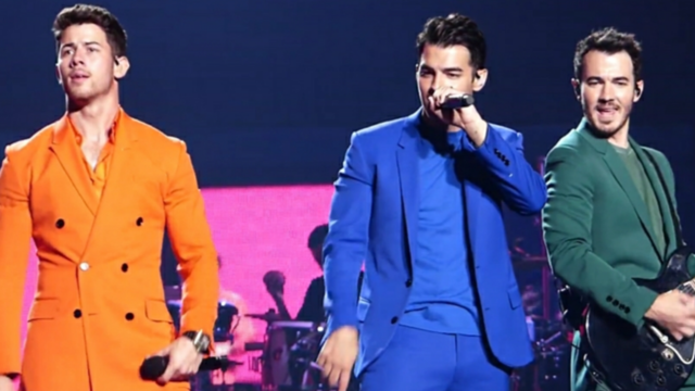 (from left) Nick, Joe and Kevin Jonas perform on stage wearing different colored suits. The Jonas Brothers have a new album releasing next Friday titled The Album.