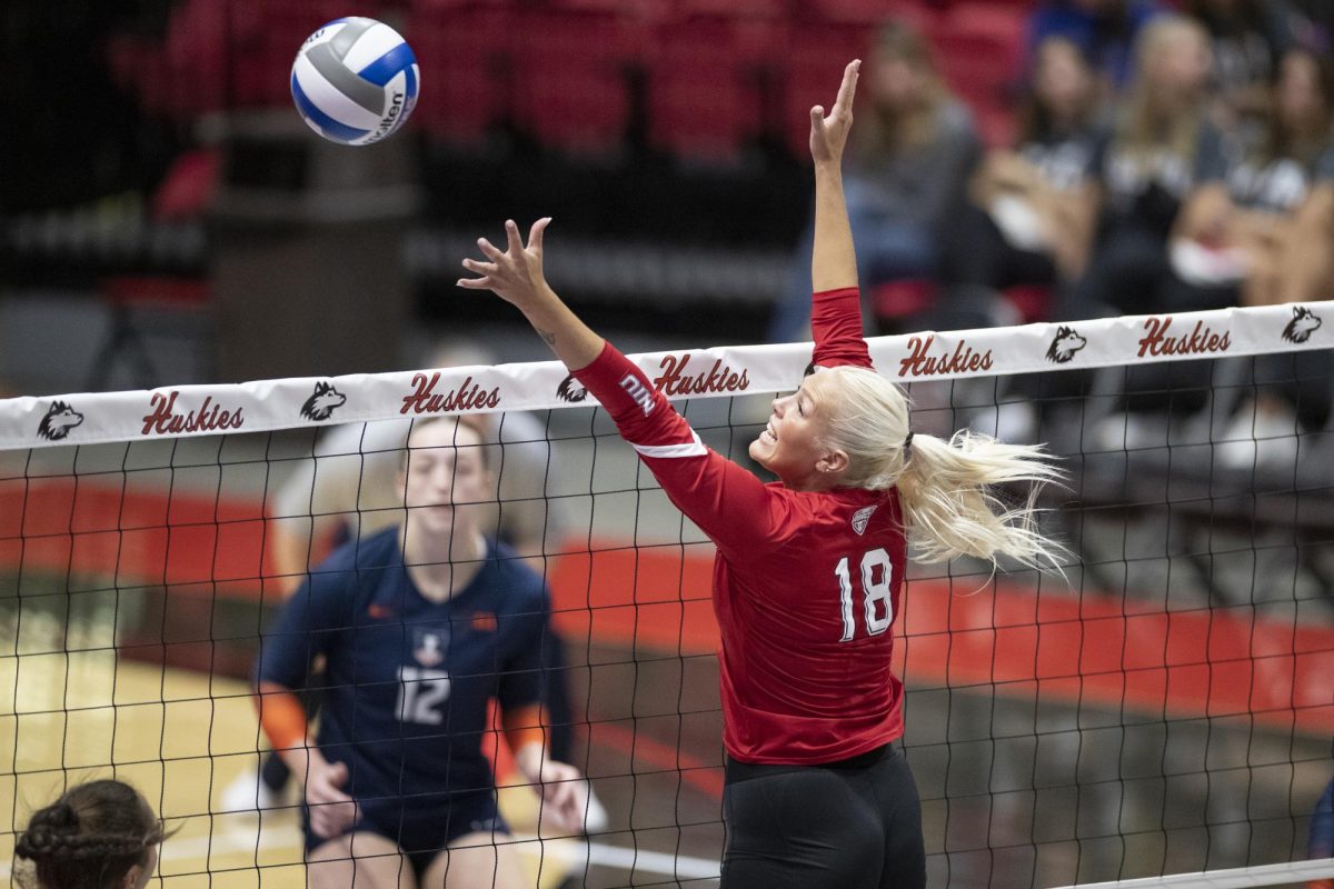 Savanah Brandt (18) jumping up to block a University of Illinois attack on Saturday. The Huskies fell to the Illini 3-1 in day 2 of the Huskie Invitational. (Scott Walstrom | NIU Athletics)